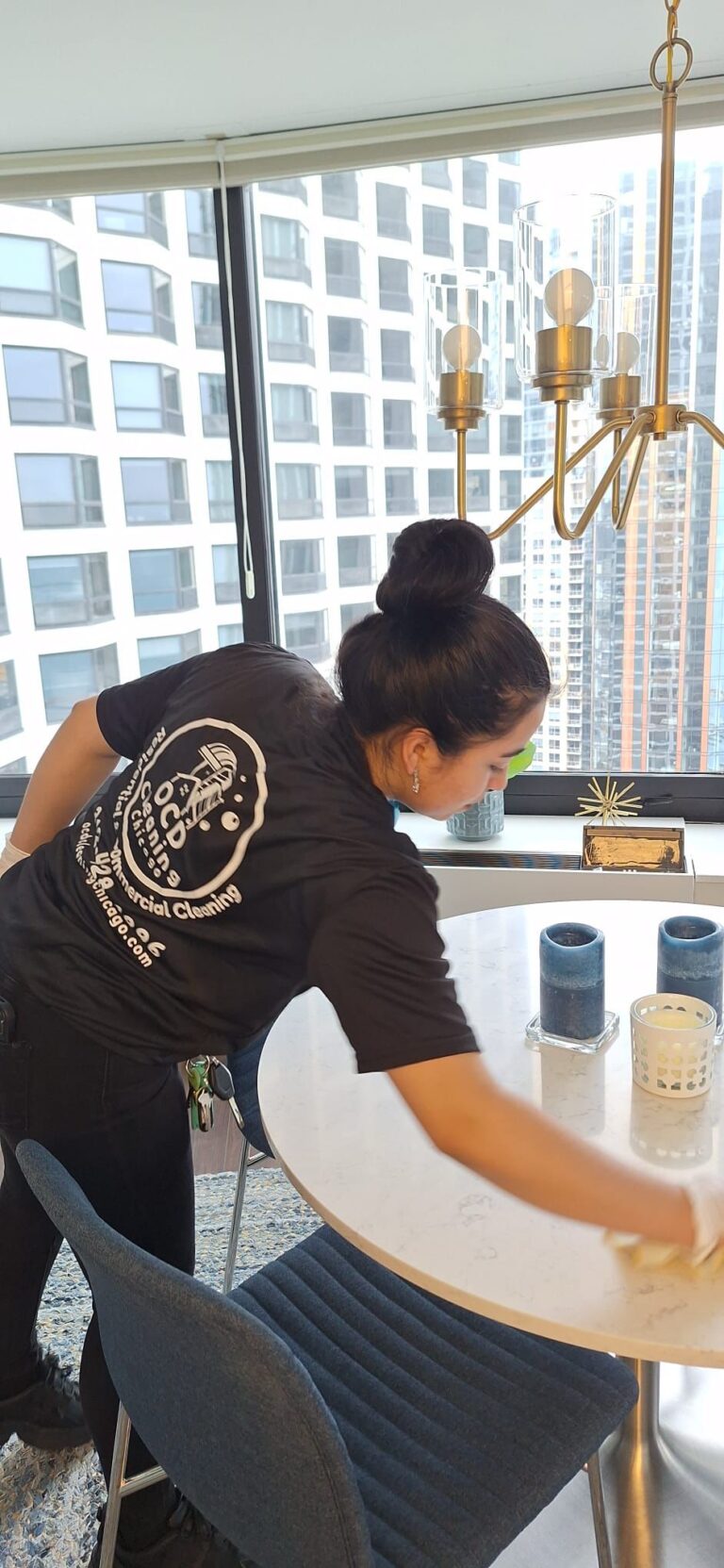 OCD cleaning specialist dusting and disinfecting a round white table