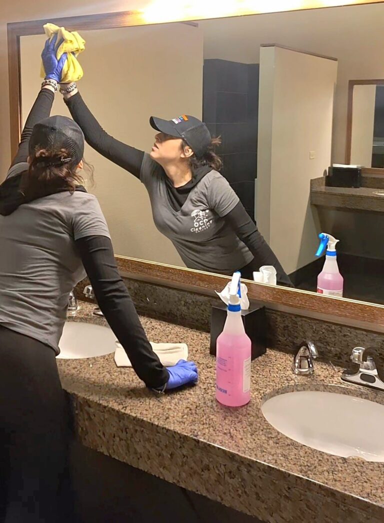 Professional OCD Cleaning Technician wiping down a mirror in a commercial space. The best cleaning services in Uptown Chicago