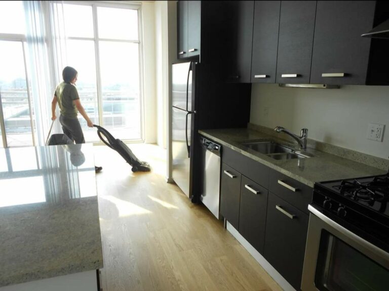 Expert OCD Cleaning specialist vacuuming a kitchen floor. The best cleaning services in Chicago. Apartment cleaning in Lake View