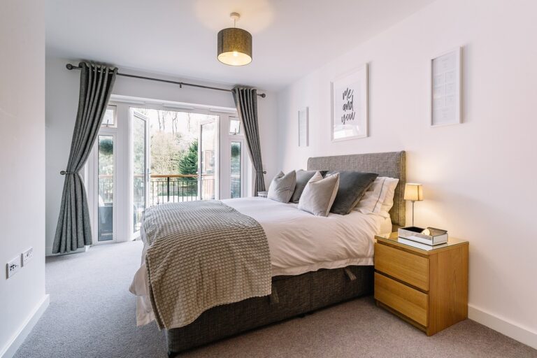 a bedroom with a bed and a door to a balcony